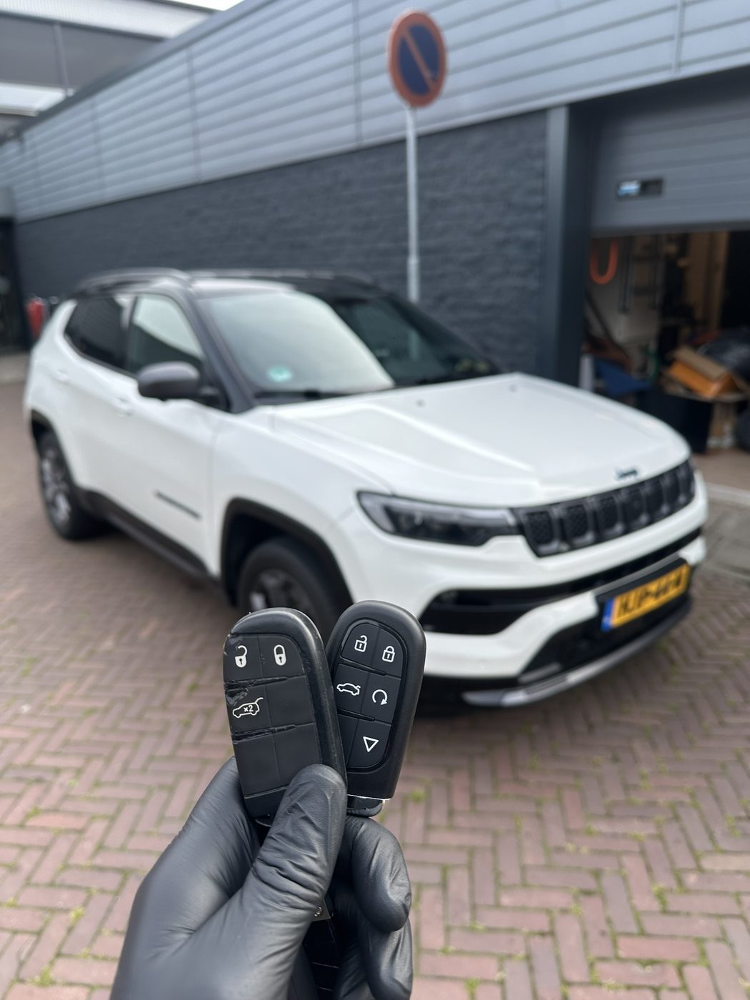 Sleutelspecialist toont twee nieuwe smart keys voor een Jeep Compass waarvan alle sleutels kwijt waren