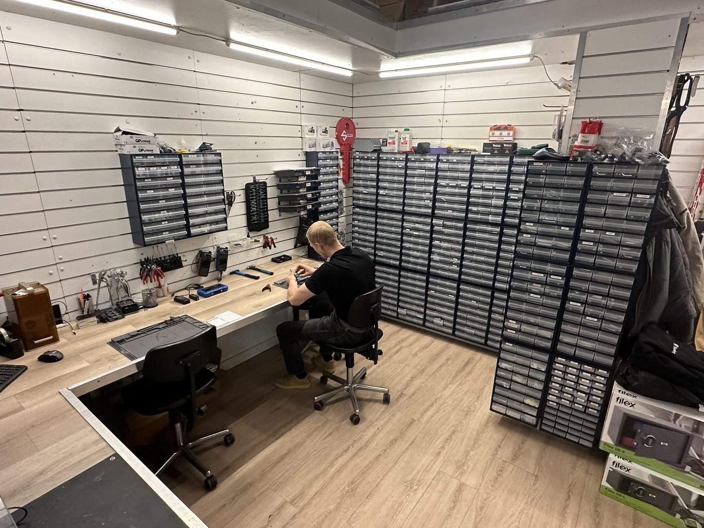 Overzicht van de werkplaats in Enschede Zuid met werkbank en voorraadkasten