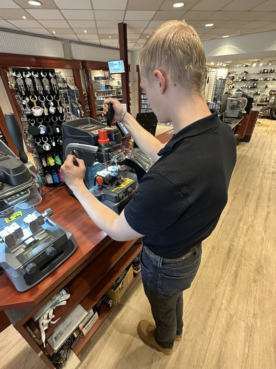 Sleutelspecialist aan de sleutelmachine in de winkel