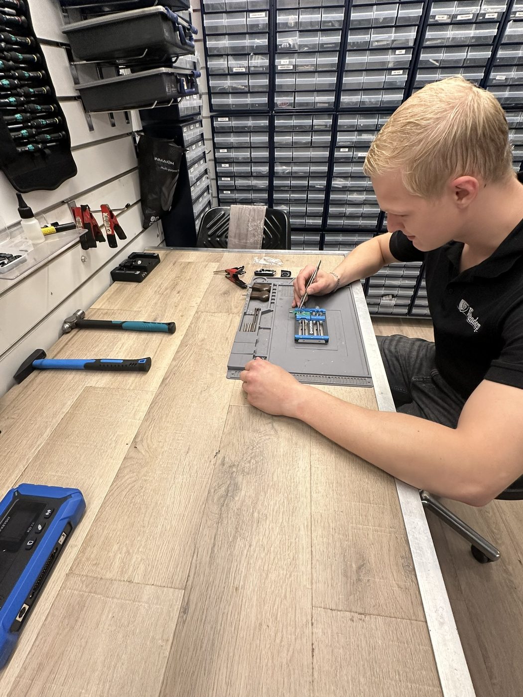 Sleutelspecialist van Westendorp programmeert een autosleutel aan de werkbank in Enschede